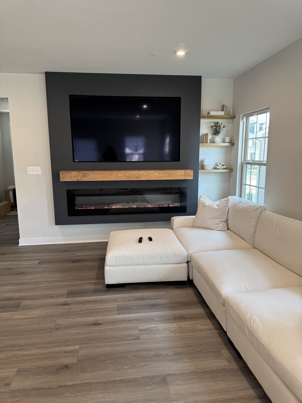 Charcoal fireplace wall with oak mantel and TV