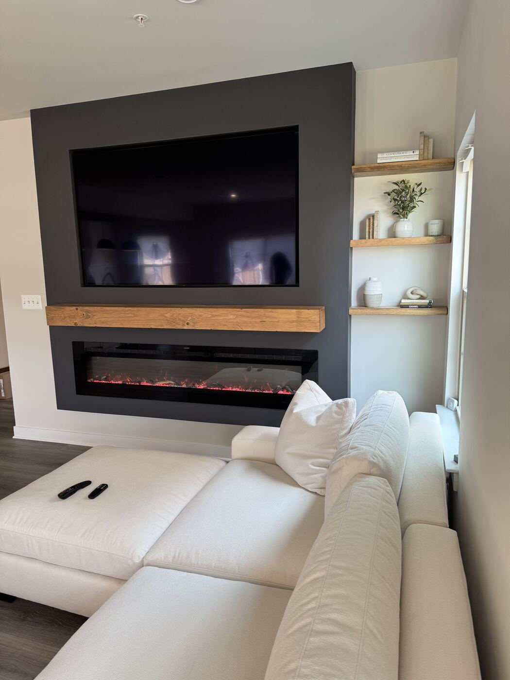 Floating oak shelves beside the fireplace wall