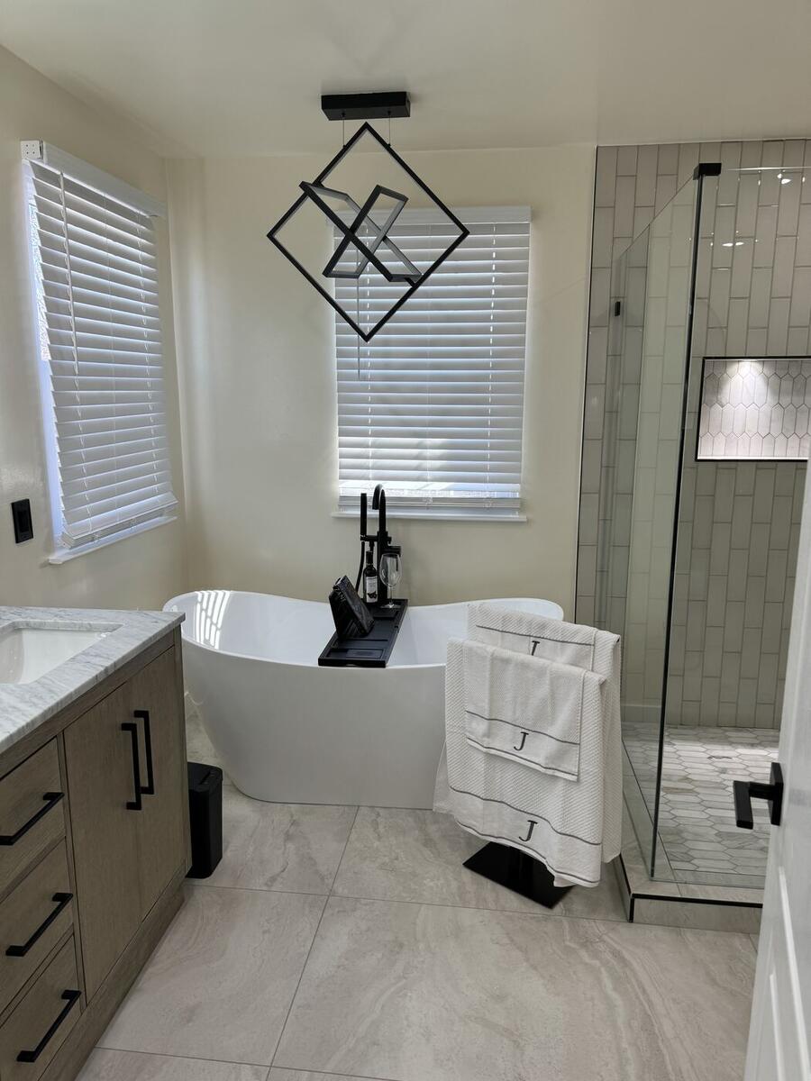 Primary bathroom with freestanding tub, frameless glass shower and double vanity
