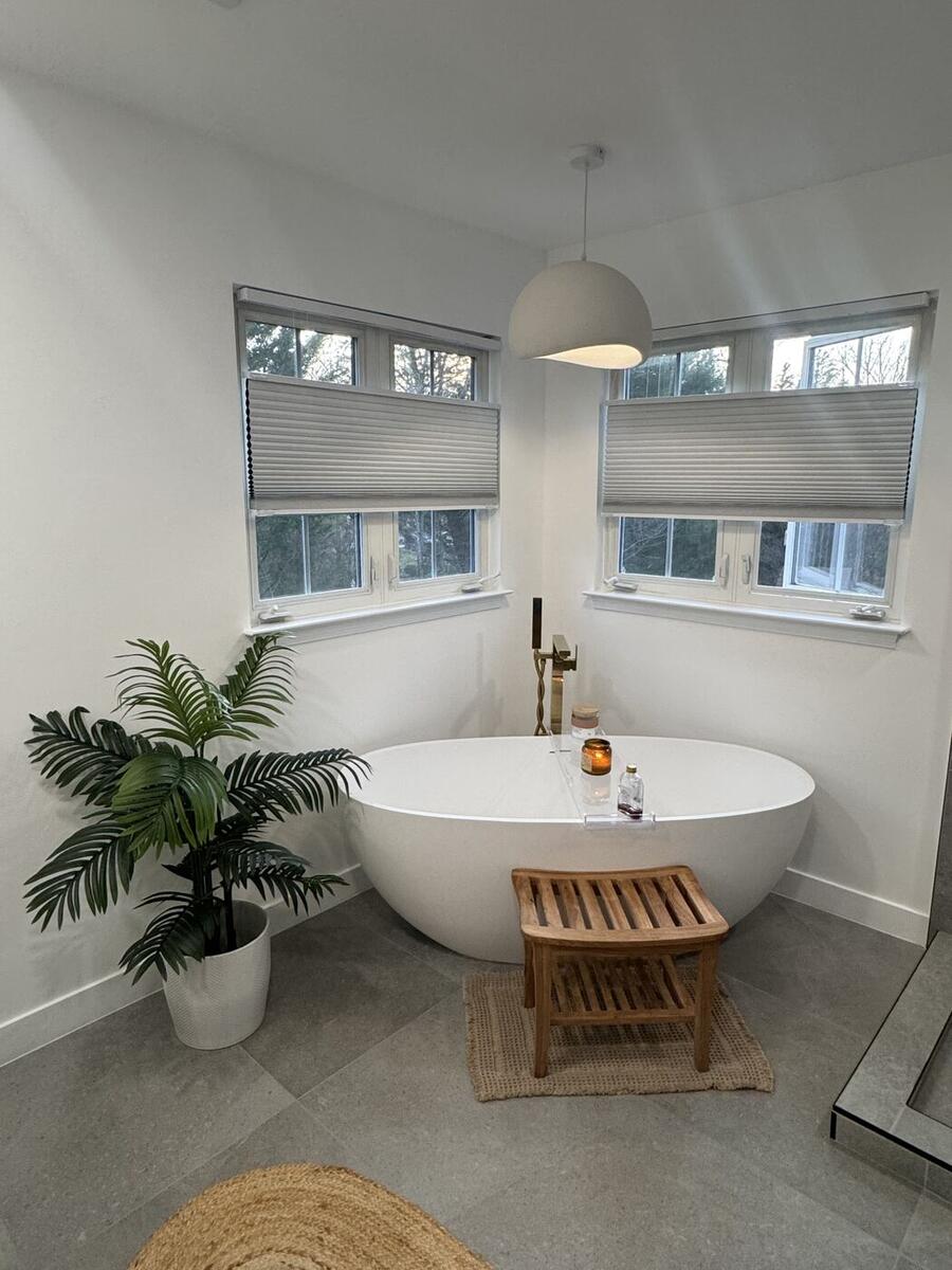 Freestanding tub in a bay window with brass filler